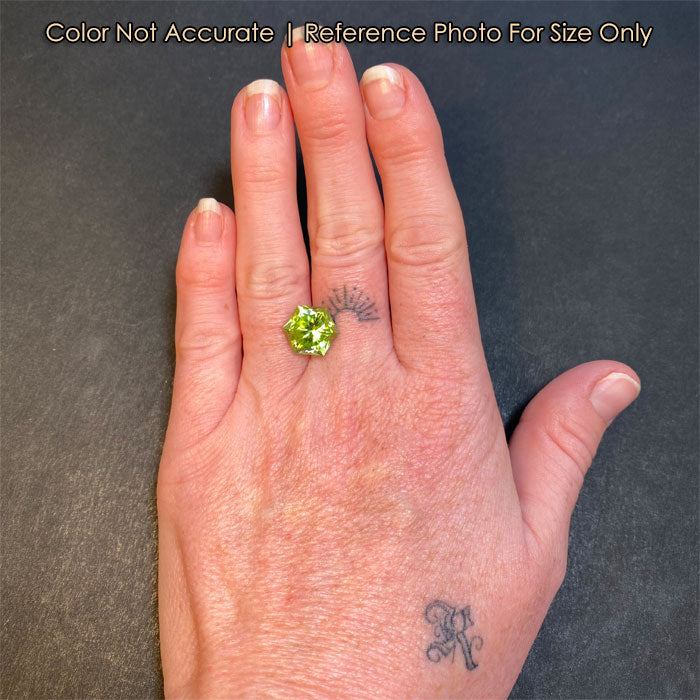 bluish green peridot gemstone on hand