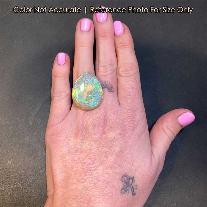 opal gemstone pear shaped on hand size reference