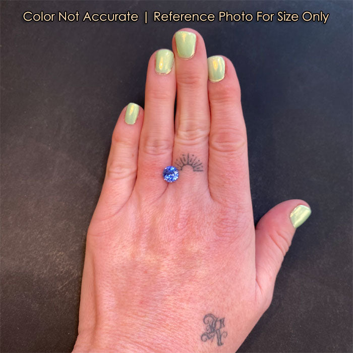 violet blue round sapphire gem on hand 