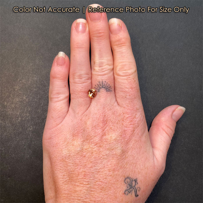 peach zircon gemstone on a hand