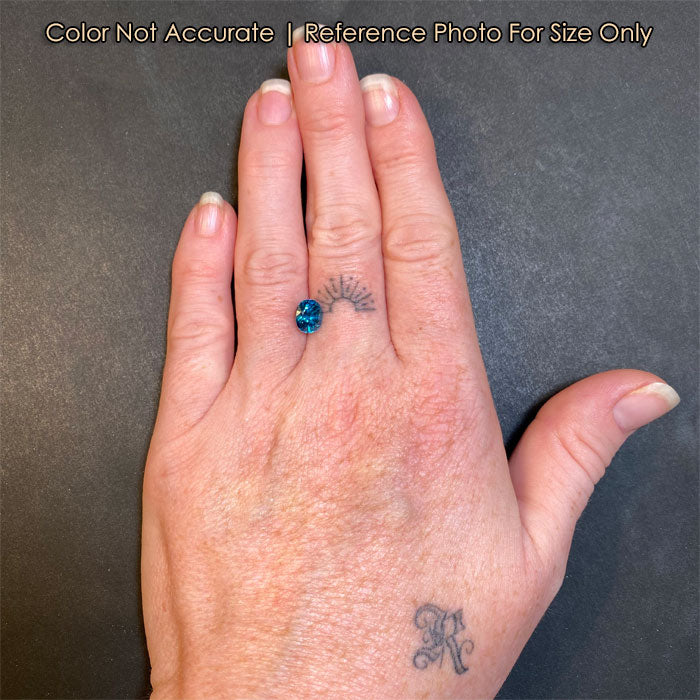 oval blue zircon gem on hand