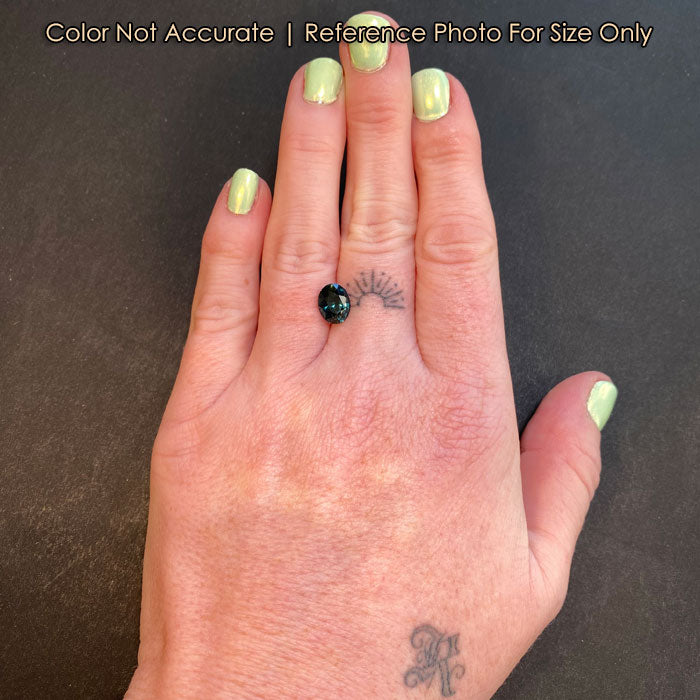 teal blue green sapphire gemstone on hand size