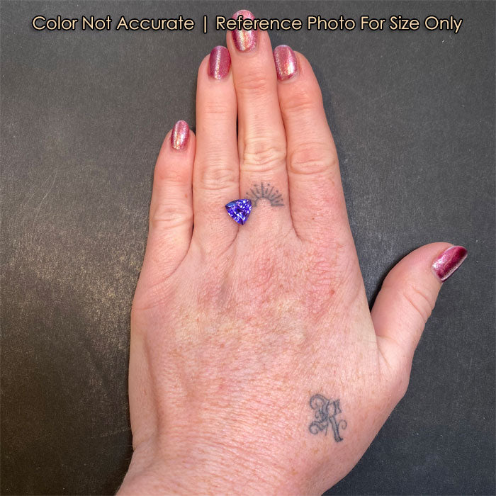 blue violet tanzanite gem on hand size 