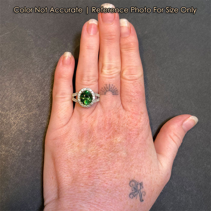 large oval garnet ring on hand with diamonds in platinum